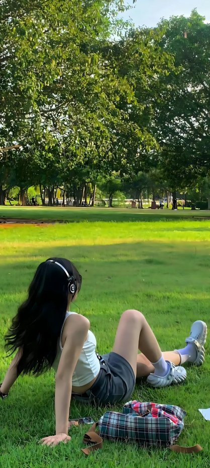 公园草坪上戴耳机少女清新风手机壁纸